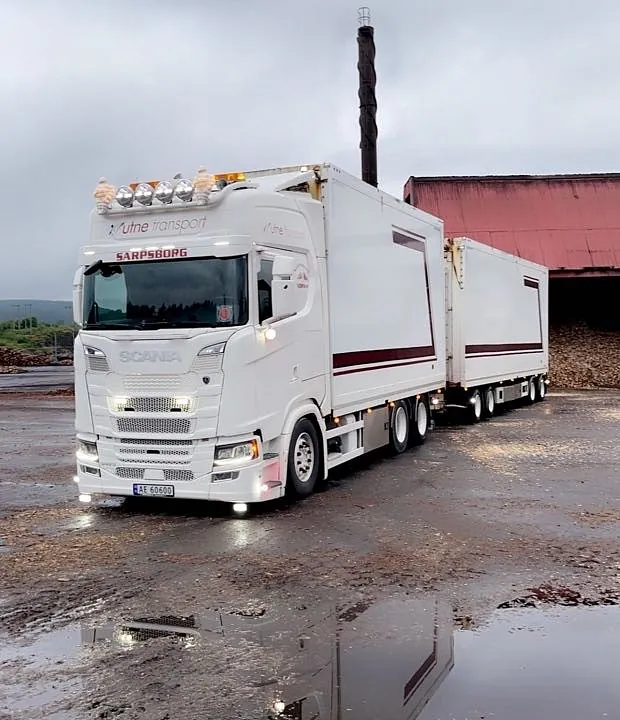 Volvo-lastebil parkert ved en rød bygning.